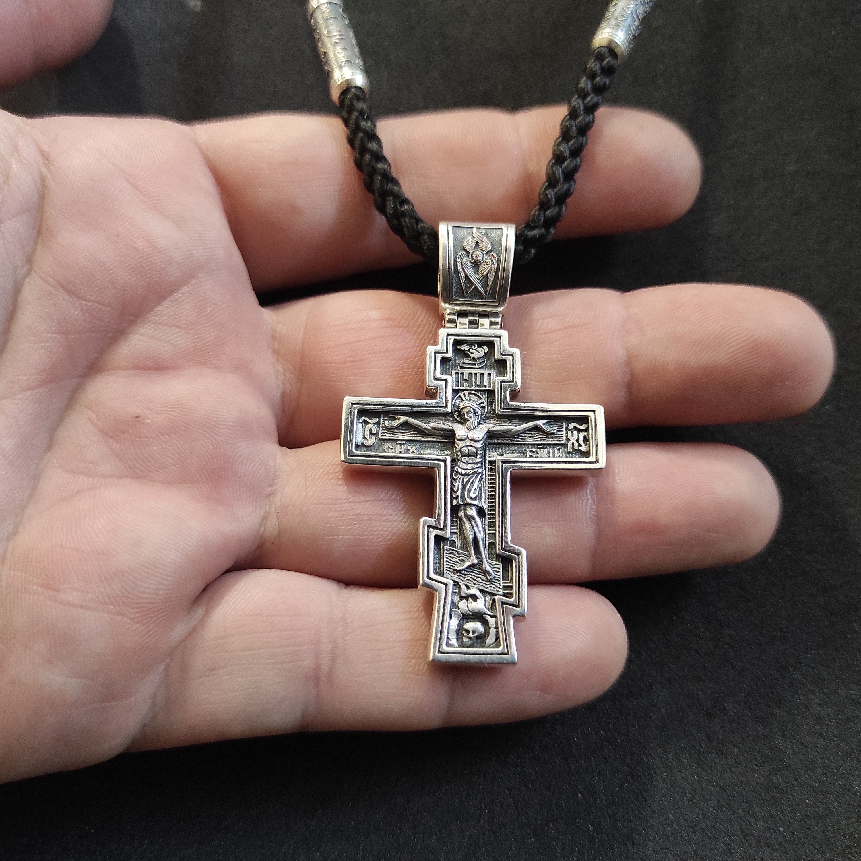 A sterling silver pendant in the shape of an Orthodox crucifix: a religious pendant.